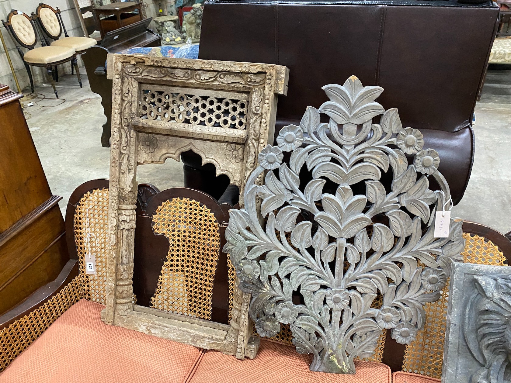 A carved Eastern hardwood window frame, height 82cm, a composition lion mask wall fountain two spoon racks and a composition wall hanging